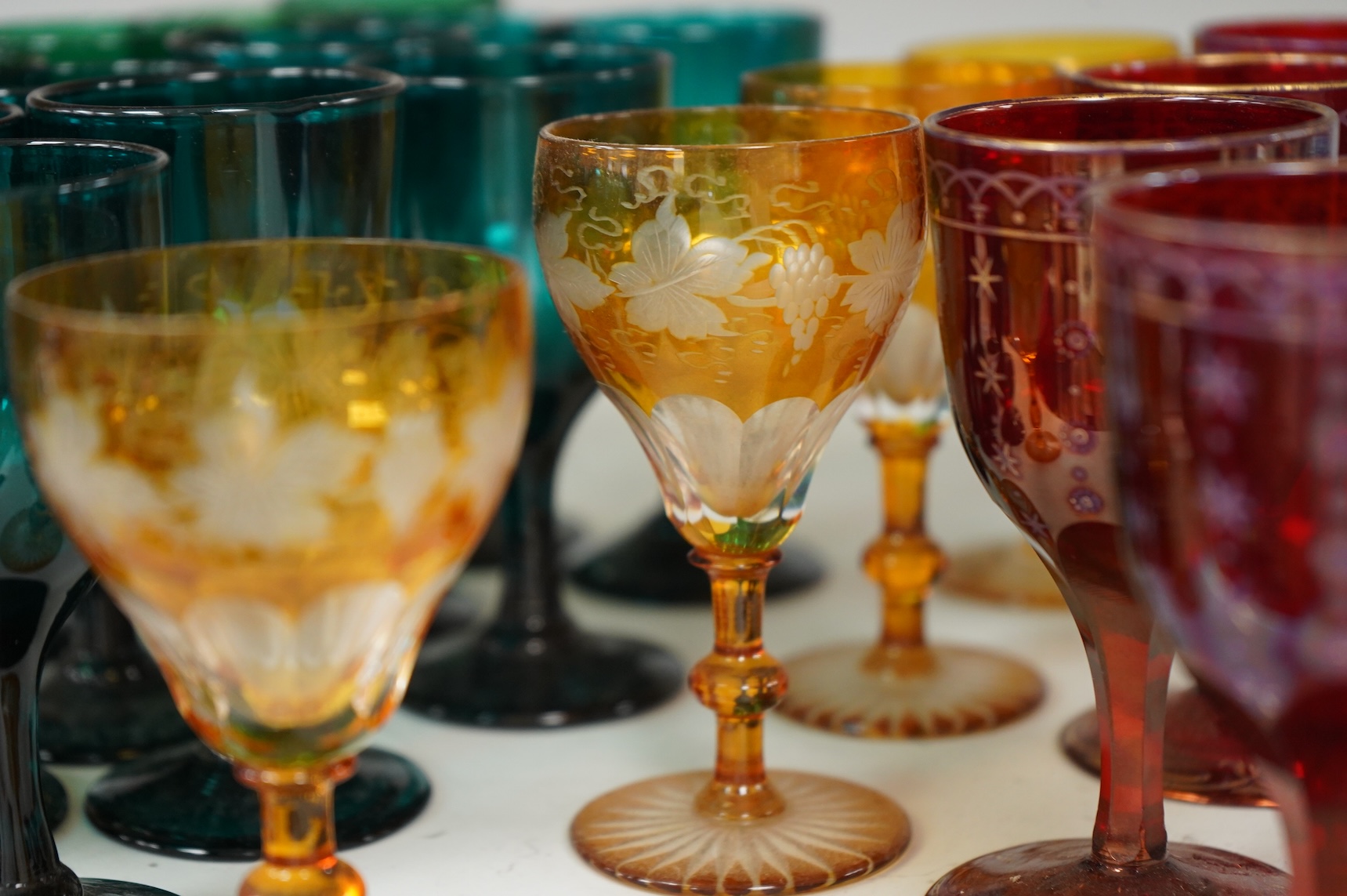 A collection of 19th century and later colour wine glasses to include amber flashed cut glasses, largest 12cm high